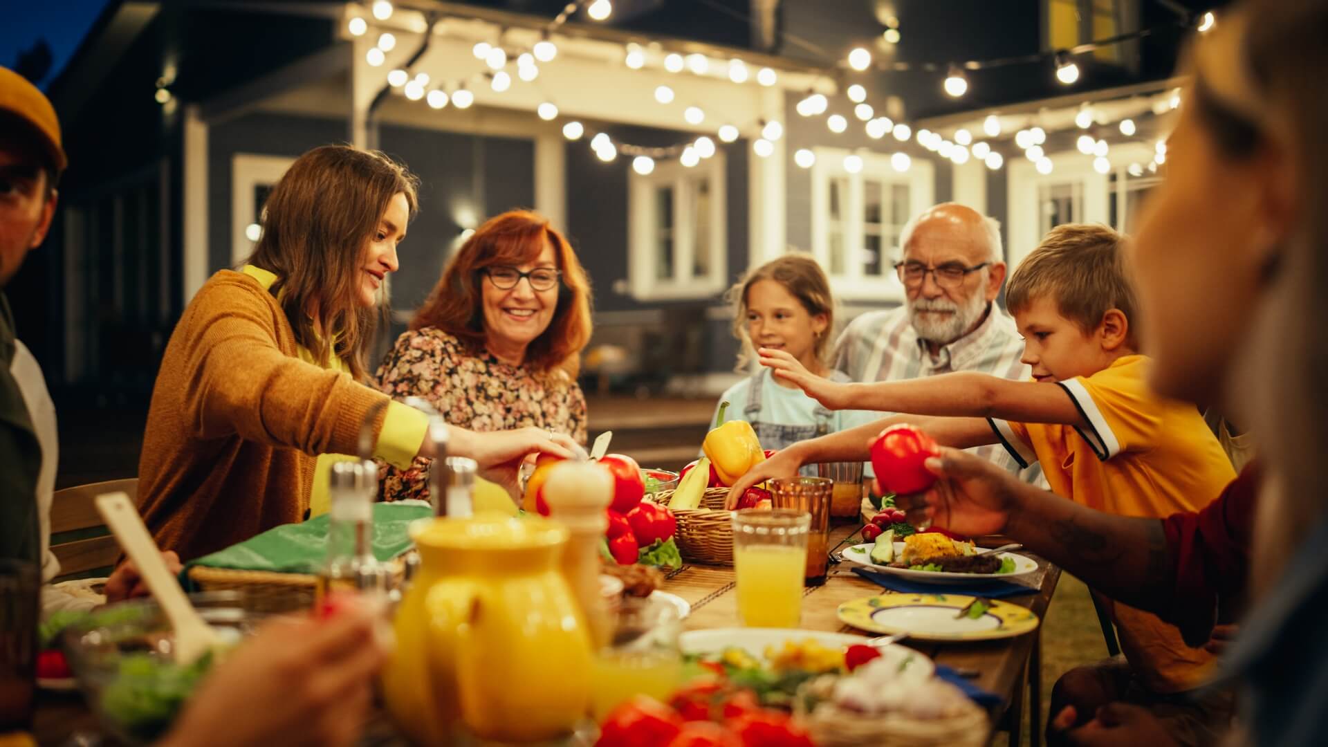 A happy family eating dinner outside.