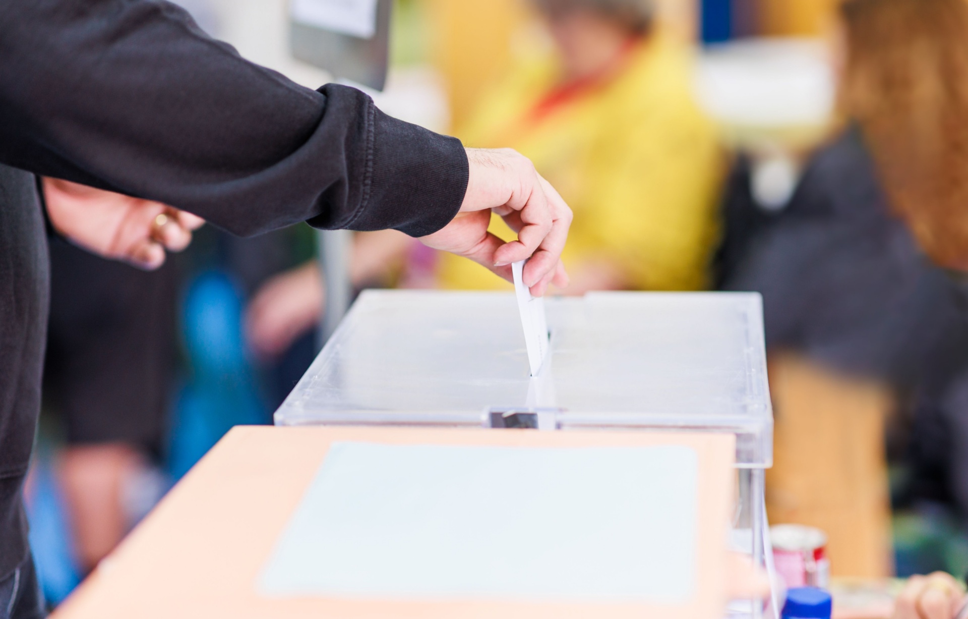 A man voting using a ballot box.