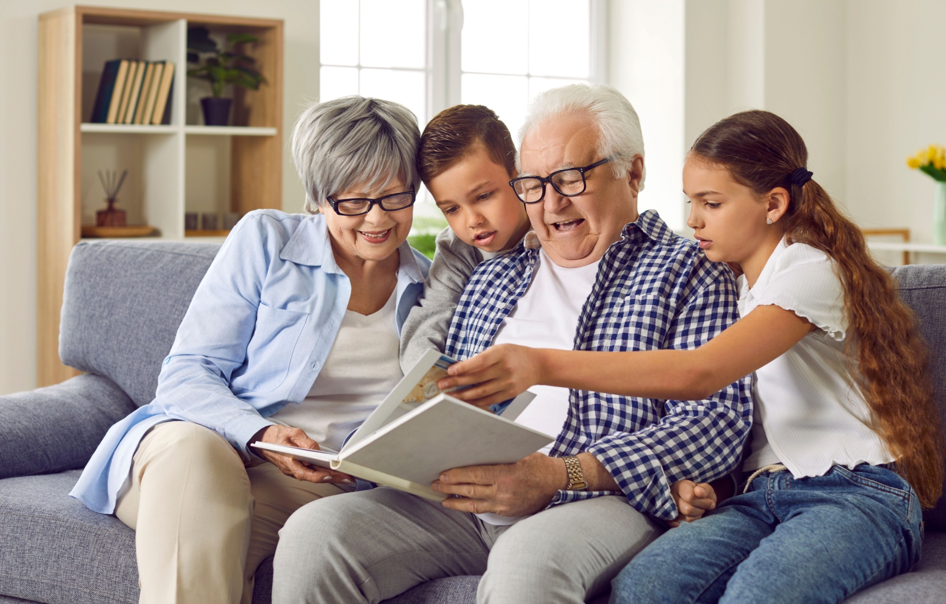 Grandparents looking at a photo album with their grandchildren.