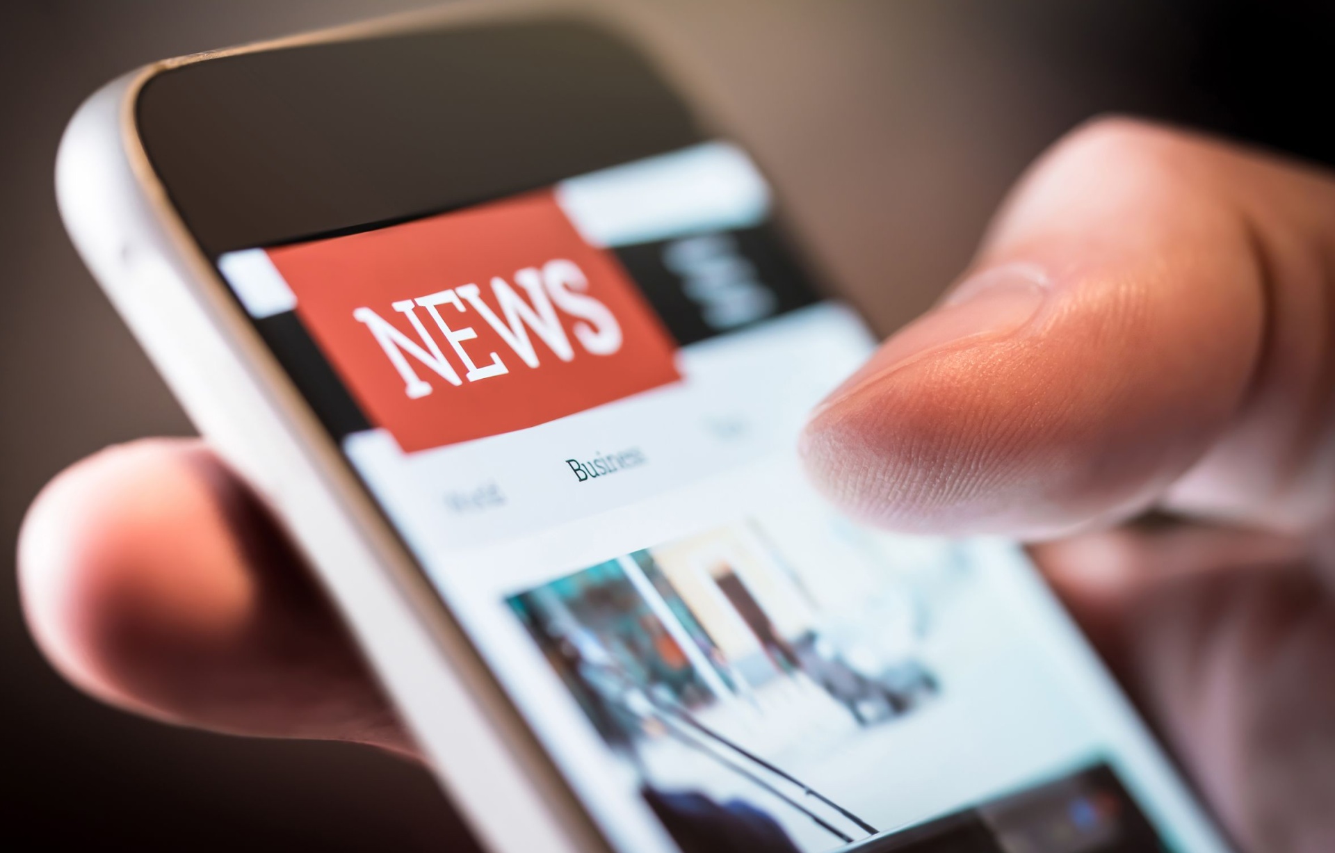 A person using a smartphone to read the news.