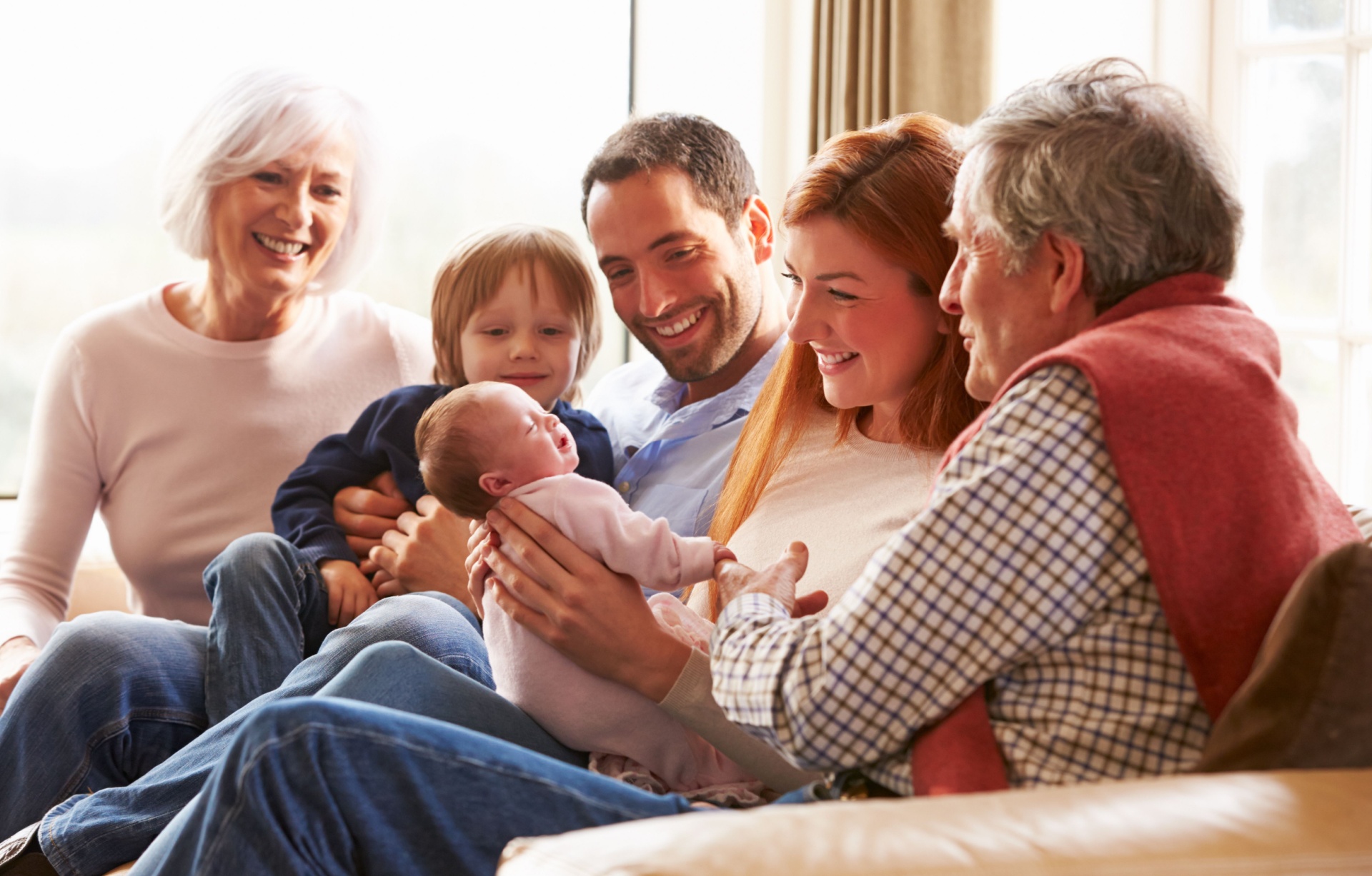 A multi-generational family sitting on the sofa.